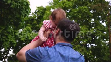 爸爸在夏天公园抱着小女儿。 爸爸和小<strong>孩子</strong>玩，<strong>哄</strong>起宝宝开心又笑。 慢慢